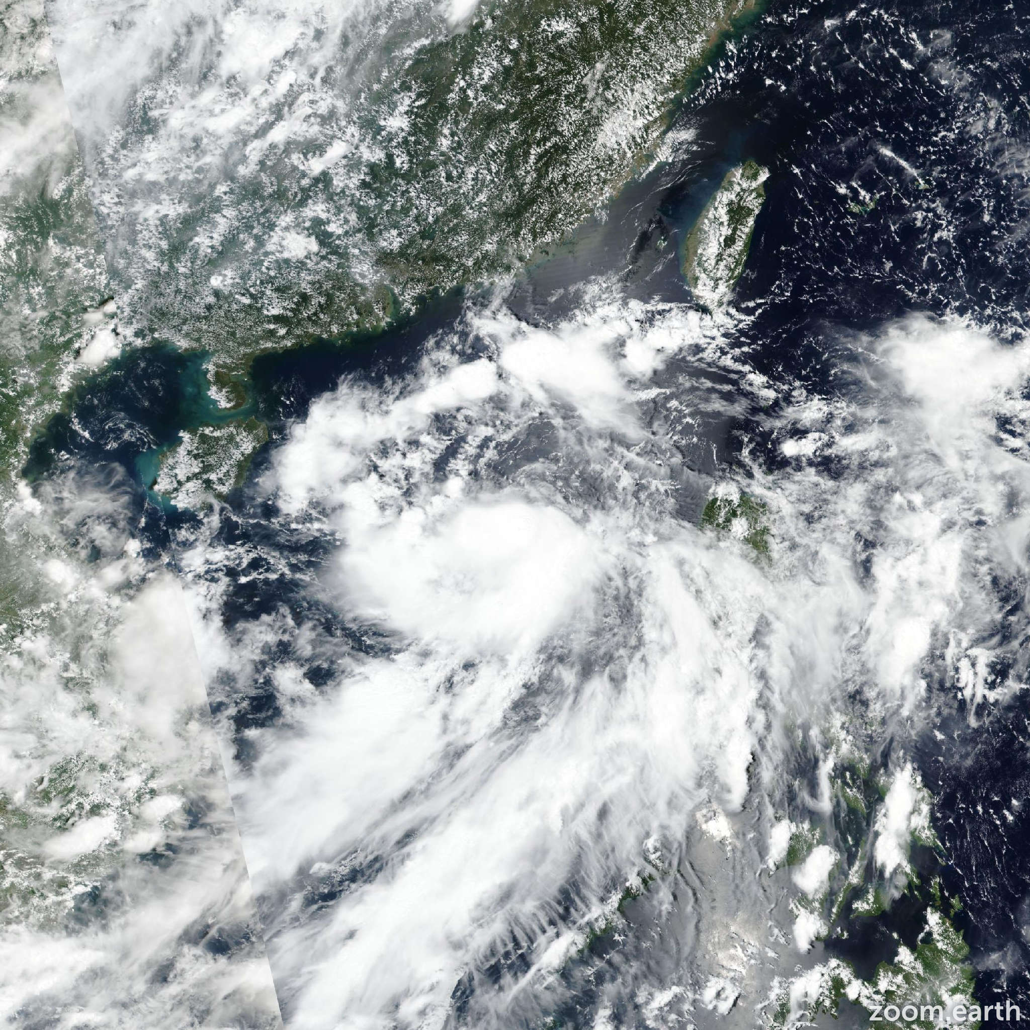 A satellite image shows a large tropical storm with dense cloud cover and swirling patterns approaching Hong Kong under the T8 storm signal, indicating significant storm activity.